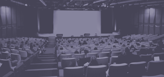 Photo de public lors d'une conférence avec filtre violet