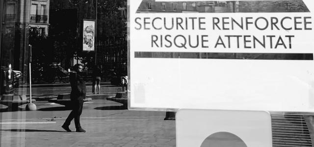 Photo noir et blanc d'un panneau "Sécurité renforcée - risque attentat" dans une rue