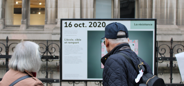 Personnes devant un panneau d'exposition