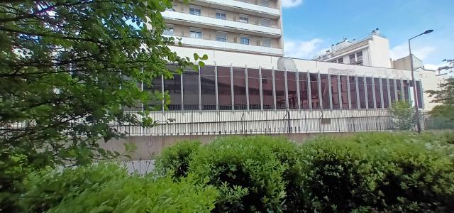Façade de la caserne Lourcine vue depuis la rue Saint-Hypolite (Paris 13)avec végétation au premier plan