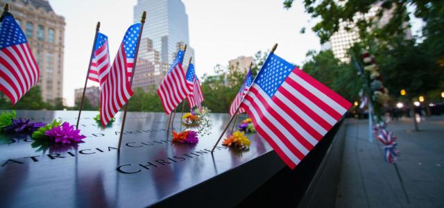 Photo de fleurs et drapeaux américains déposés au Mémorial du 11-Septembre à New-York