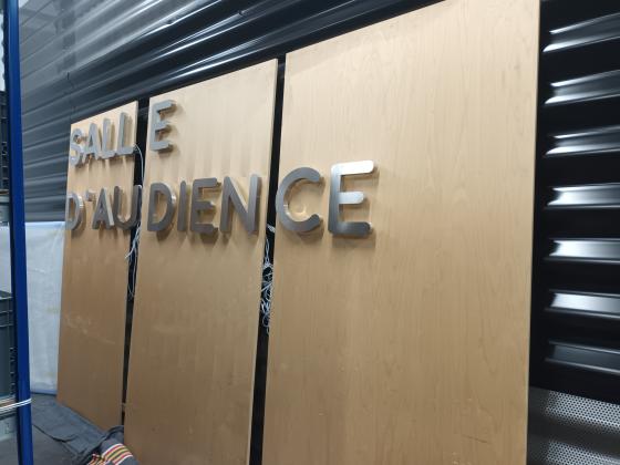 3 panneaux de bois formant les mots "Salle d'audience"