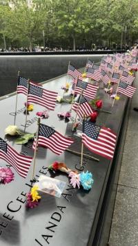 Fleurs et drapeaux américains posés sur les bassins mémoriels à Ground Zero