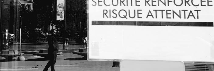 Photo noir et blanc d'un panneau "Sécurité renforcée - risque attentat" dans une rue