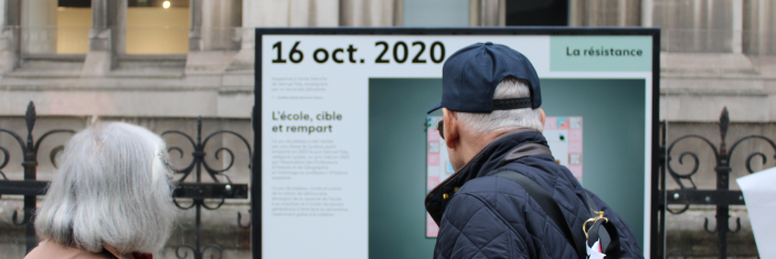 Personnes devant un panneau d'exposition