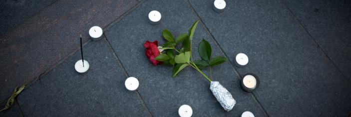 Bougies disposées autour d'une rose rouge sur le sol