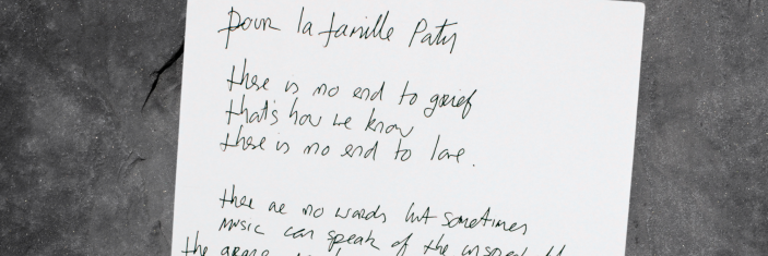 Lettre de Bono à la famille Paty posée sur un fond gris foncé