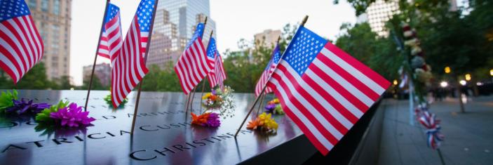 Photo de fleurs et drapeaux américains déposés au Mémorial du 11-Septembre à New-York
