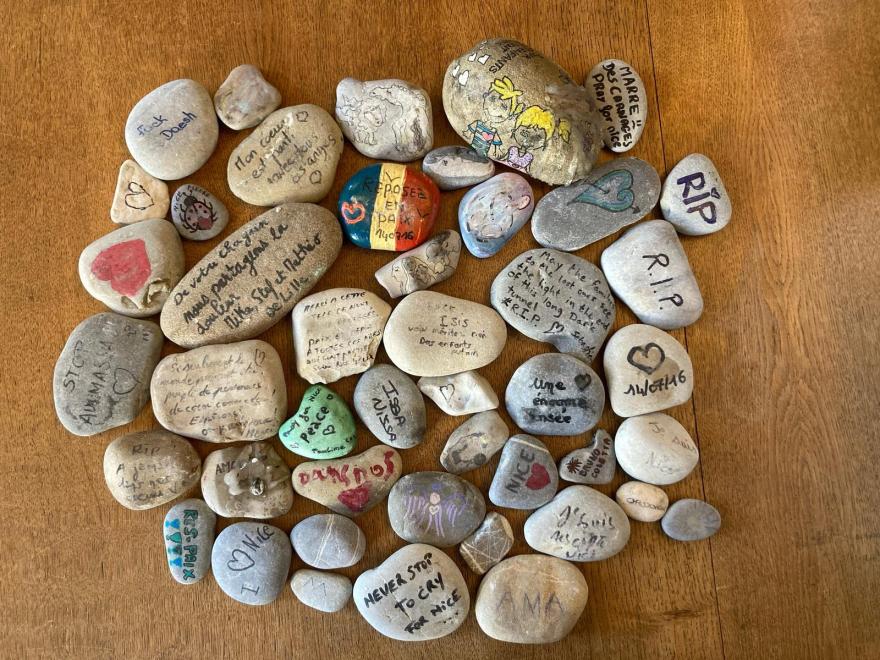 photographie présentant des galets peints en hommage aux victimes de l'attentat du 14 juillet 2016 à Nice