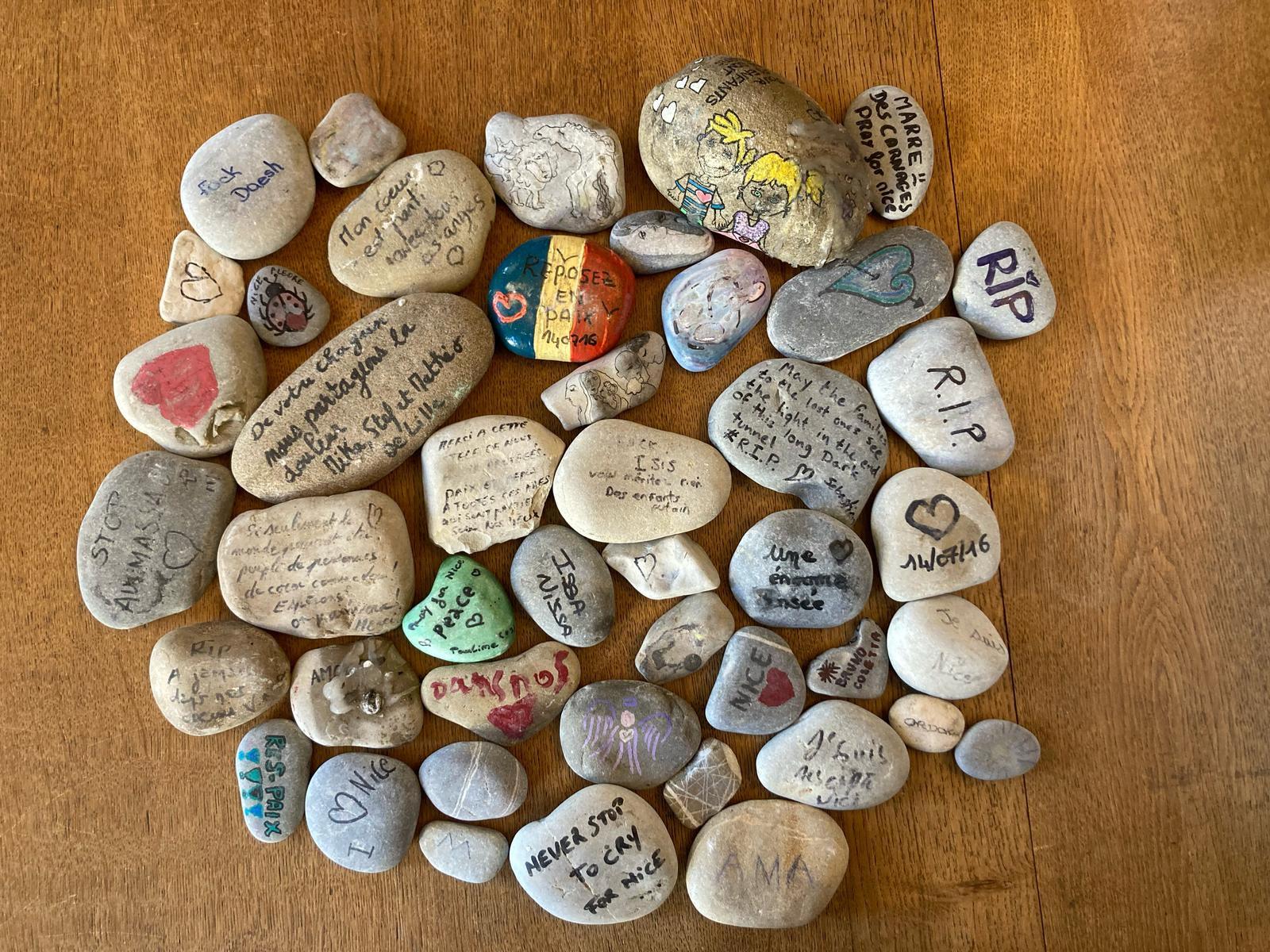 photographie présentant des galets peints en hommage aux victimes de l'attentat du 14 juillet 2016 à Nice